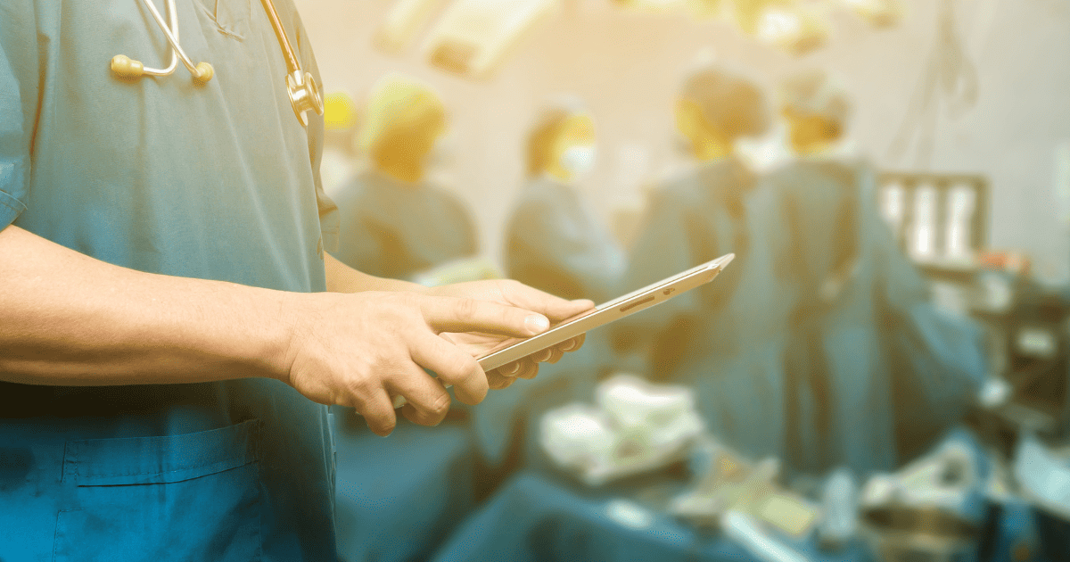 Surgeon in an operating room holding an iPad.